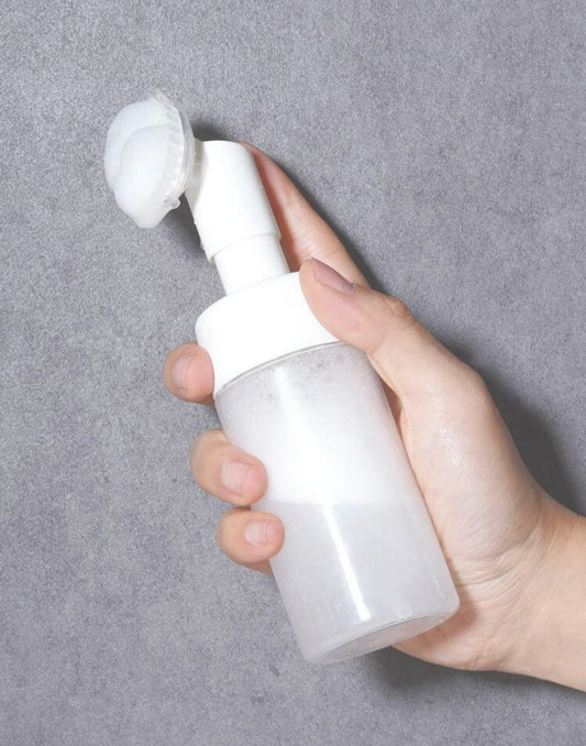 Facial cleansing bottle with brush